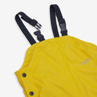 Close-up of yellow 'Puddleflex' waterproof dungarees with navy blue straps and buckles. Focus on the upper part of the garment.